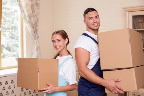 Mover wearing PPE while carrying a boxed item carefully
